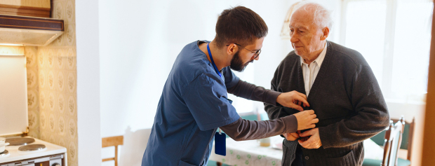 social- og sundhedshjælper hjælper ældre mand