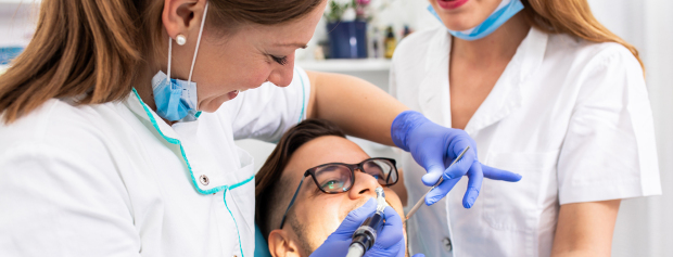 tandklinikassistenter undersøger patient